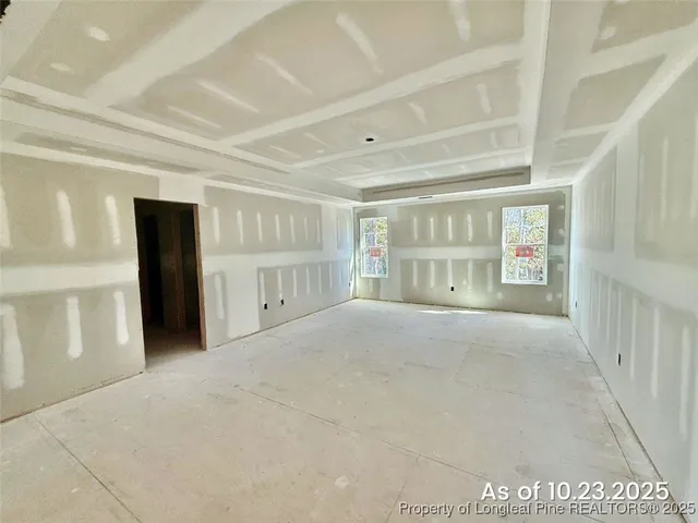 a view of an empty room with closet and a window