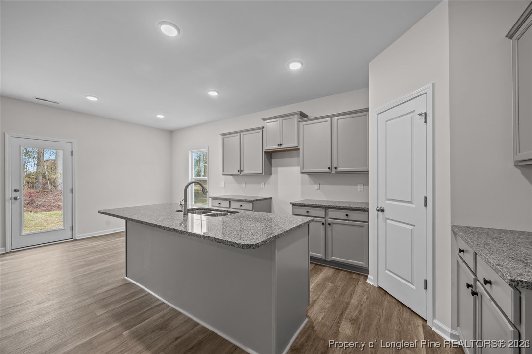 96 Regis Lane Coats, NC 27521 - Photo 7 of 36 a kitchen with kitchen island granite countertop a sink cabinets and stainless steel appliances