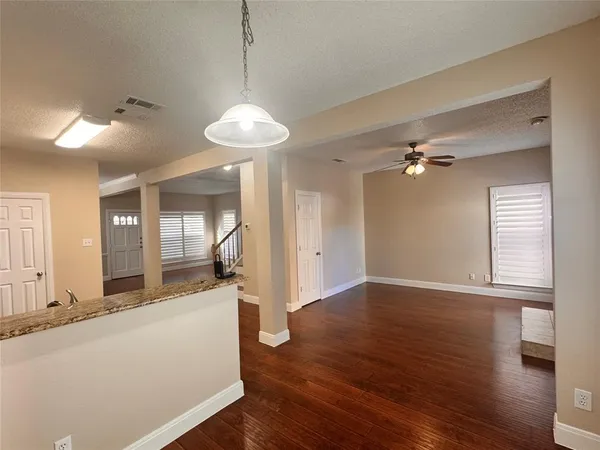 a view of a big room with wooden floor and a chandelier