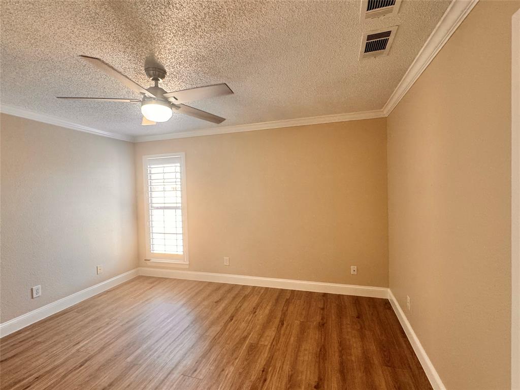 9435 Blue Jay Way Irving, TX 75063 - Photo 18 of 27 an empty room with wooden floor fan and windows