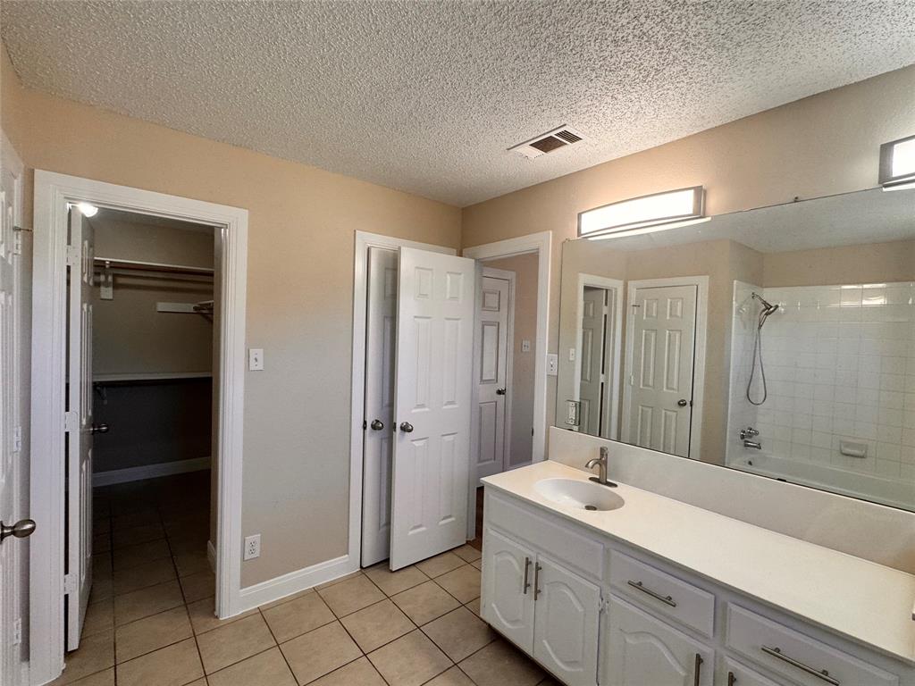 9435 Blue Jay Way Irving, TX 75063 - Photo 21 of 27 a bathroom with a shower sink and mirror