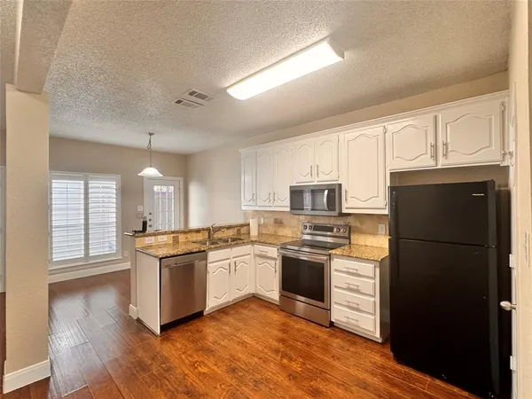 a kitchen with cabinets stainless steel appliances and window