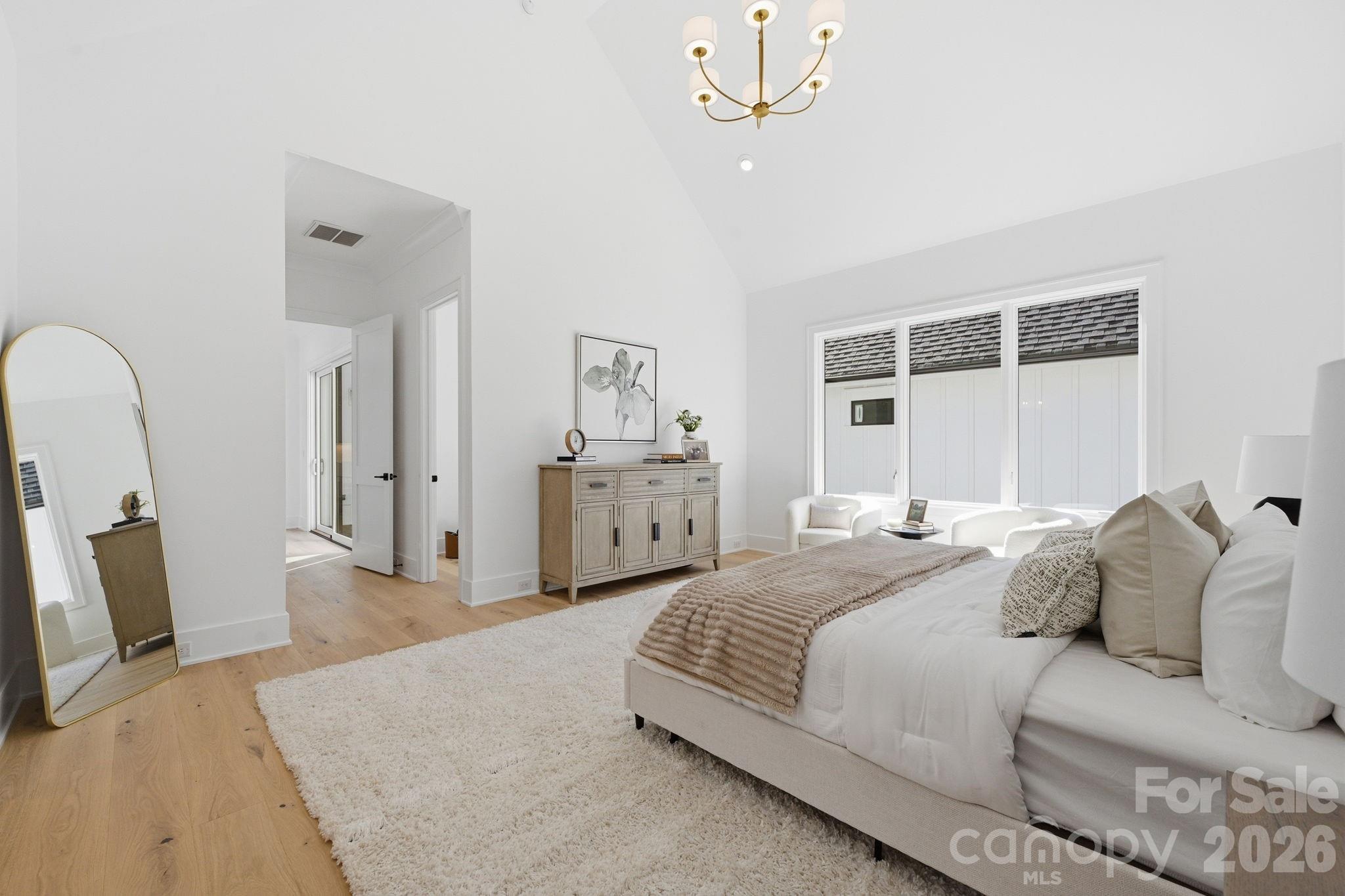 610 Walnut Street Davidson, NC 28036 - Photo 18 of 33 a spacious bedroom with a bed a chandelier and dresser