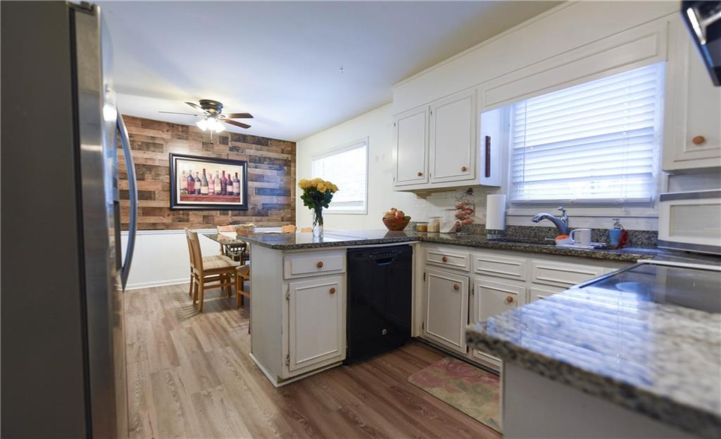 3280 Devilla Trace College Park, GA 30349 - Photo 4 of 21 a kitchen with granite countertop a stove top oven a sink a dining table and chairs
