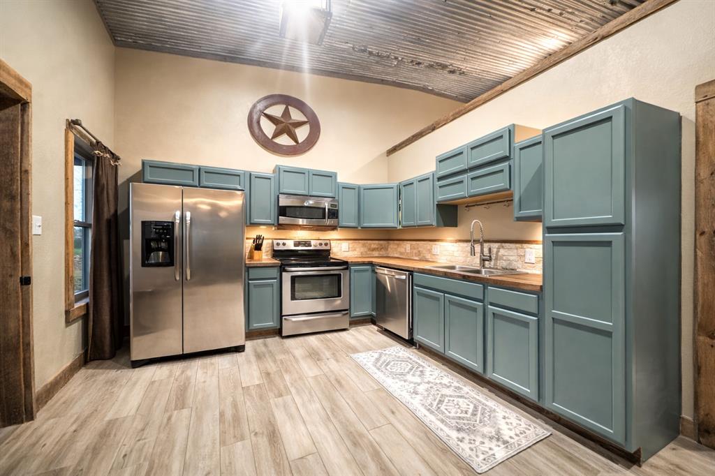 6187 Mockingbird Lane Murchison, TX 75778 - Photo 2 of 11 a kitchen with stainless steel appliances granite countertop a refrigerator and a stove