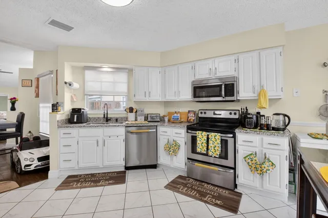 a kitchen with a sink a stove and cabinets