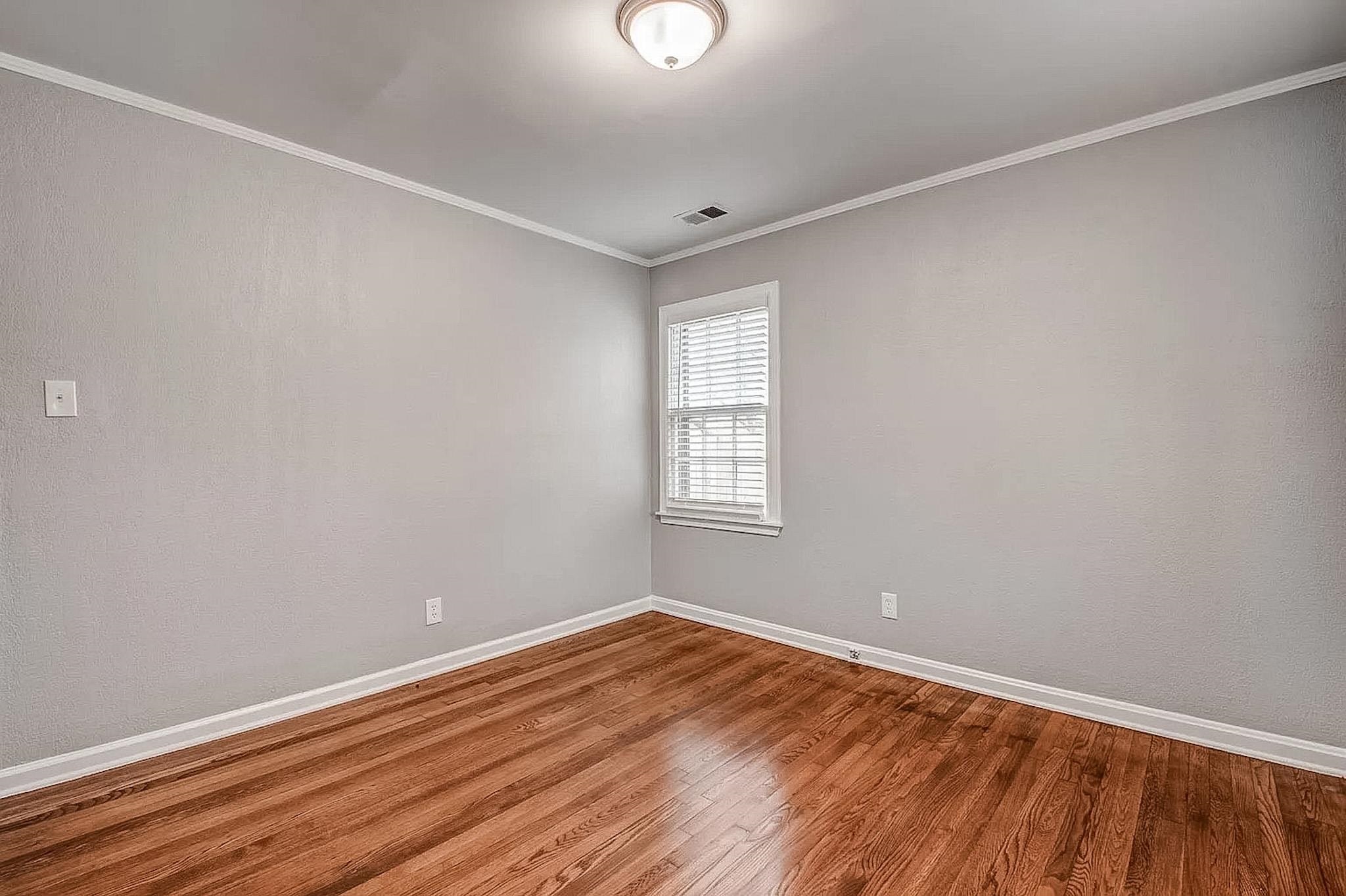 4402 Boyce Road Memphis, TN 38117 - Photo 9 of 13 an empty room with wooden floor and windows