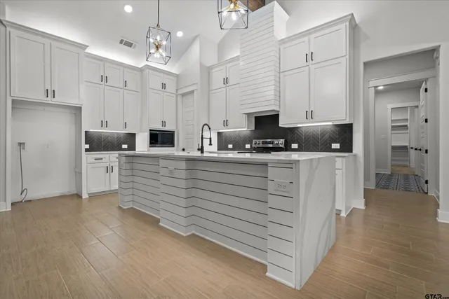 a kitchen with granite countertop cabinets a sink a stove and a dining table