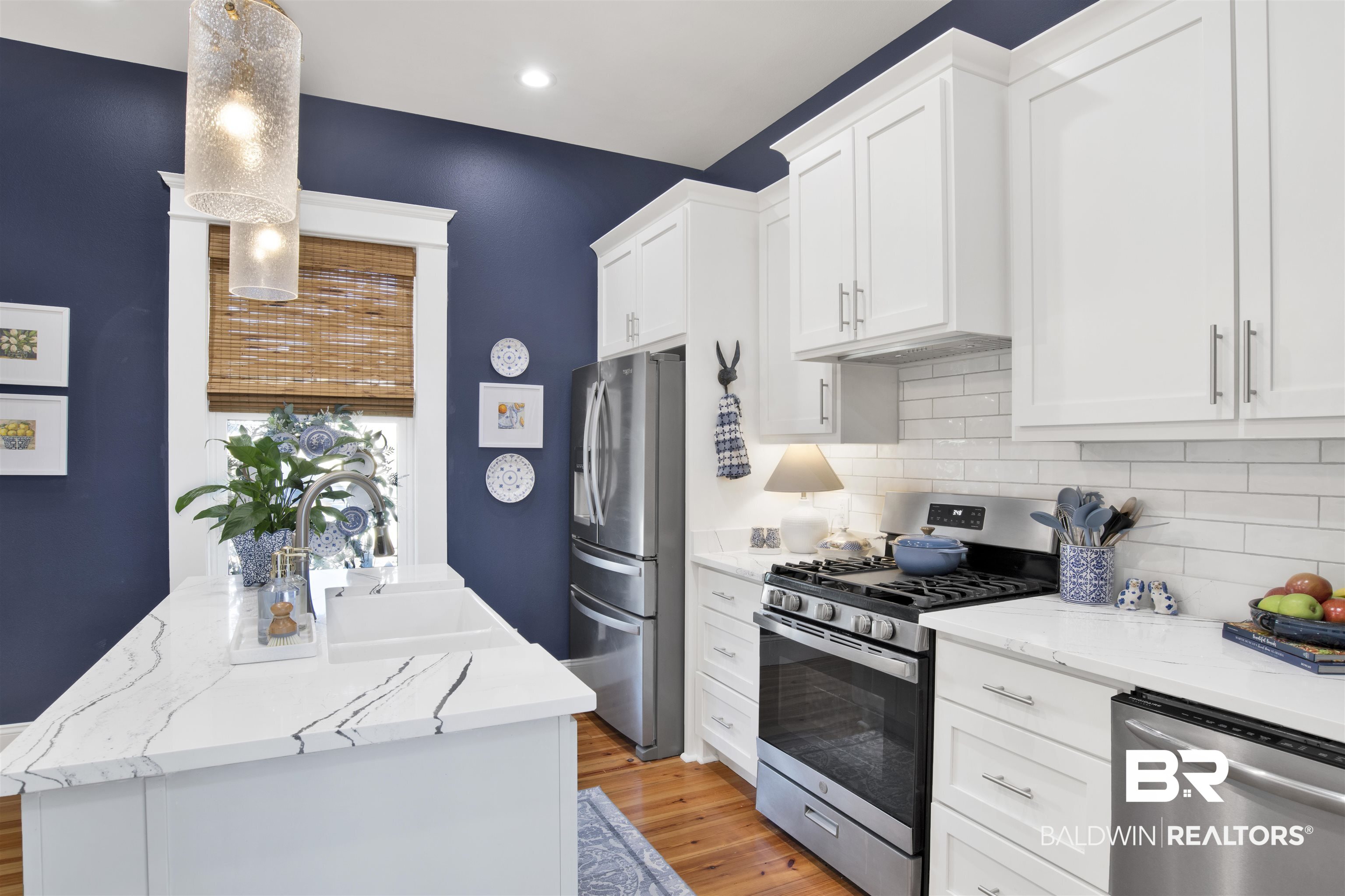 12094 Old Federal Road Magnolia Springs, AL 36555 - Photo 14 of 48 Kitchen with appliances with stainless steel finishes, tasteful backsplash, white cabinetry, sink, and pendant lighting