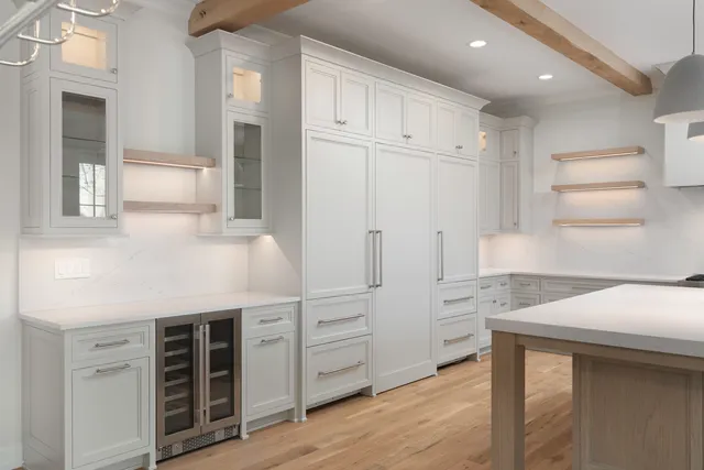 a kitchen with white cabinets and refrigerator