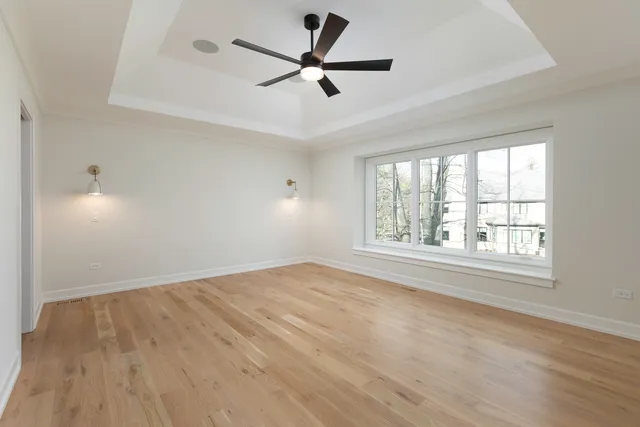 a view of a big room with wooden floor and windows