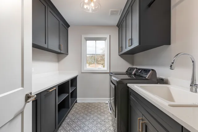 an empty room with chandelier fan and windows