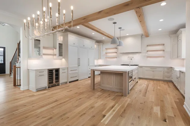 a large kitchen with stainless steel appliances a large counter top a sink a stove and a refrigerator