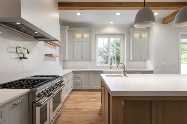 a kitchen with granite countertop a sink stainless steel appliances and cabinets