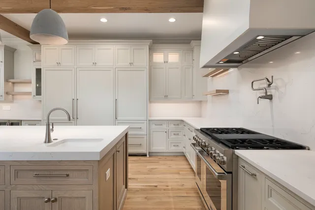 a kitchen with white cabinets and sink