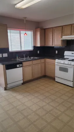 a kitchen with a sink cabinets and window