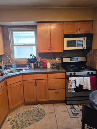 a kitchen with stainless steel appliances granite countertop a stove a sink and a microwave