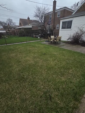a view of backyard with seating space and wooden fence