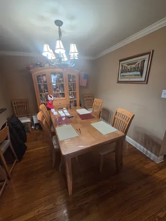 a view of a dining room with furniture a chandelier and wooden floor