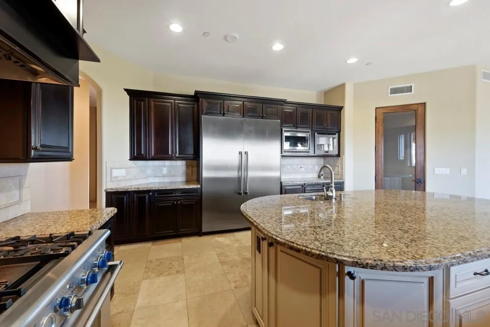 18121 El Brazo Rancho Santa Fe, CA 92067 - Photo 7 of 25 a kitchen with kitchen island granite countertop a sink stainless steel appliances and cabinets
