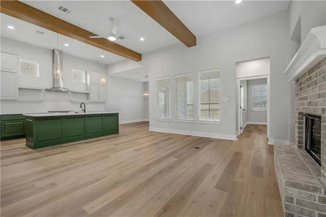 a view of empty room with wooden floor and fireplace