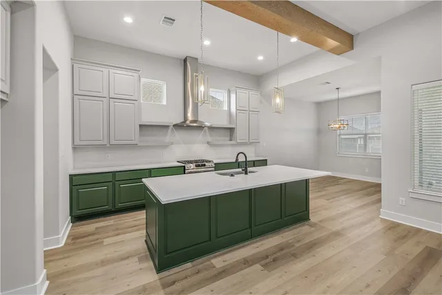 an empty room with wooden floor cabinet and windows