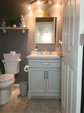 a bathroom with a toilet sink and mirror