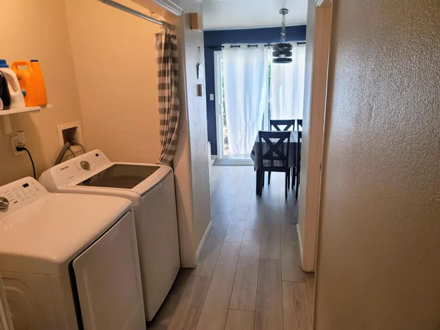 a hallway with a view of bedroom with wooden floor
