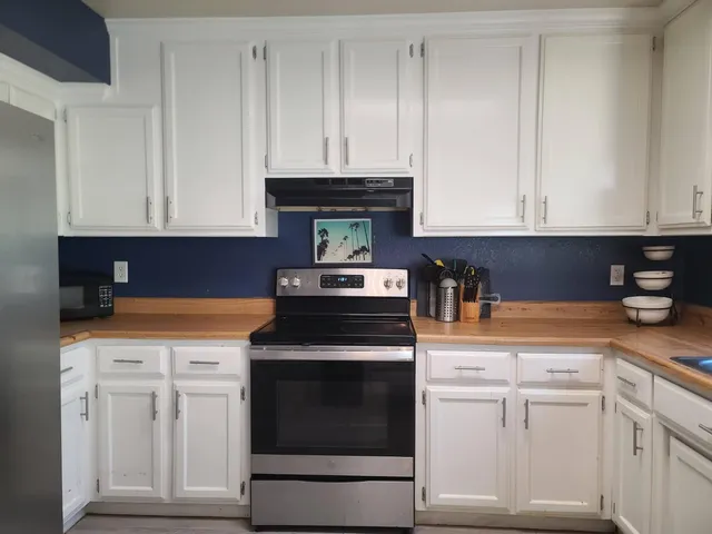 a kitchen with white cabinets and white appliances