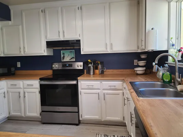 a kitchen with granite countertop white cabinets and sink