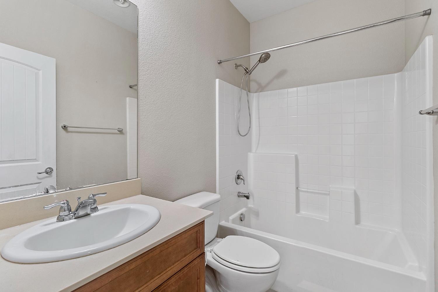 7525 Eldred Way Sacramento, CA 95829 - Photo 14 of 38 bathroom with vanity, shower / bathtub combination, and a textured wall