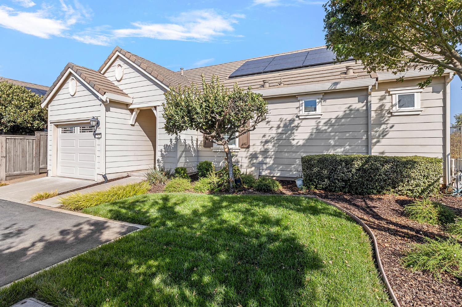 7525 Eldred Way Sacramento, CA 95829 - Photo 24 of 38 view of front of house with an attached garage, solar panels, and driveway