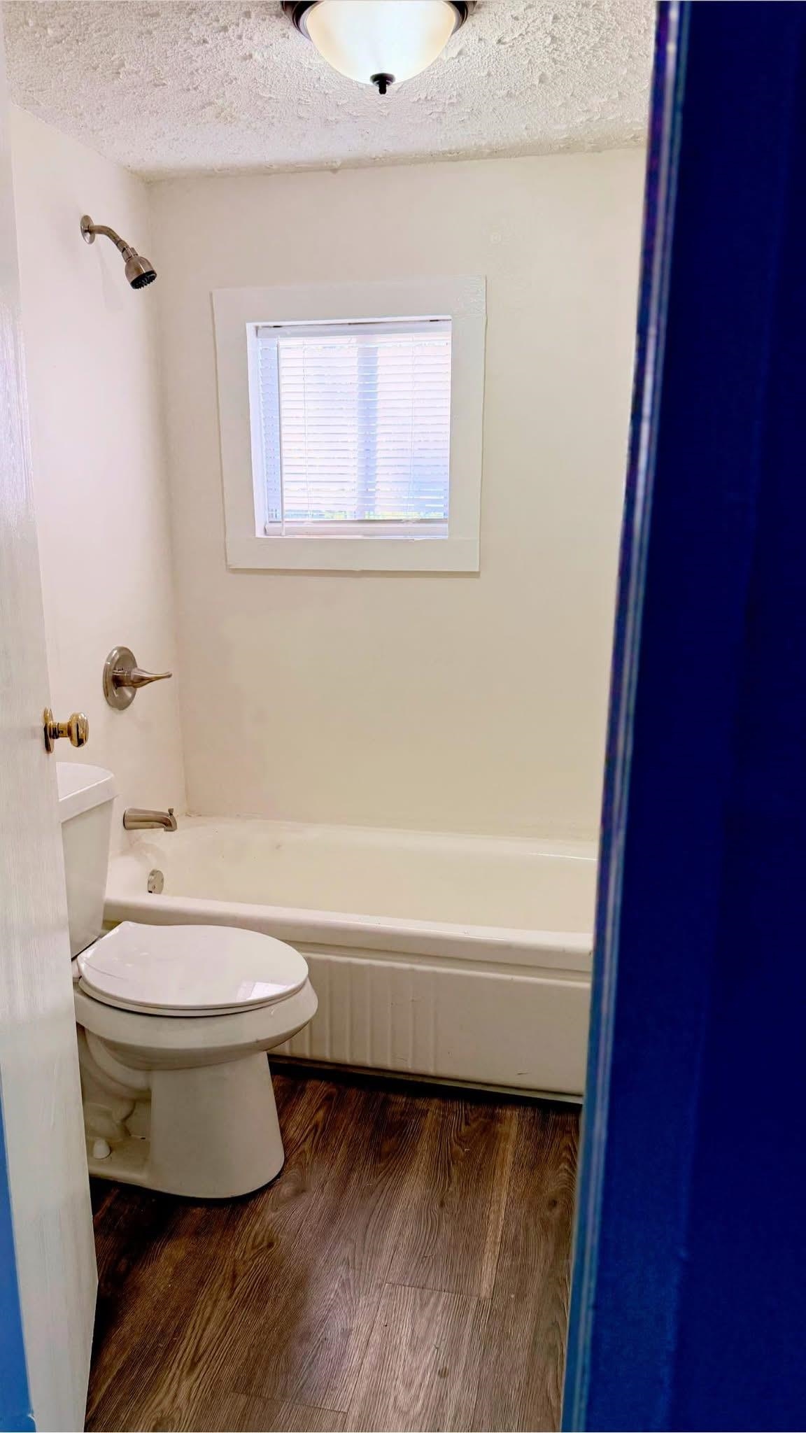 1393 Michigan Street Memphis, TN 38106 - Photo 5 of 9 Bathroom with tub / shower combination, wood-type flooring, a textured ceiling, and toilet