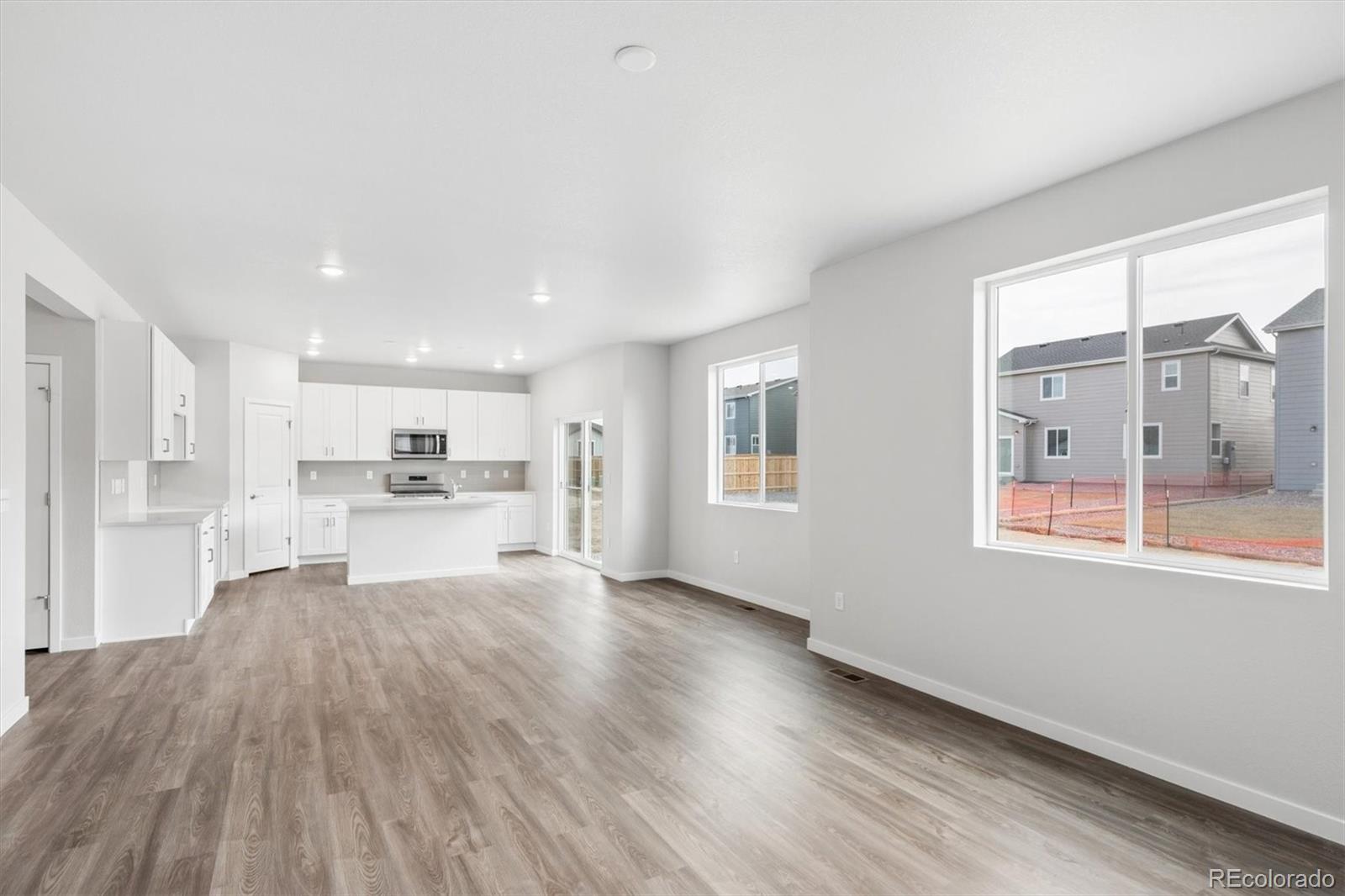 1414 Farmstead Street Brighton, CO 80601 - Photo 11 of 26 a view of kitchen with wooden floor and windows