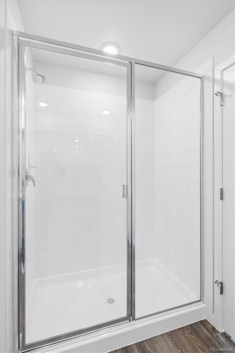 1414 Farmstead Street Brighton, CO 80601 - Photo 16 of 26 a bathroom with a glass shower door
