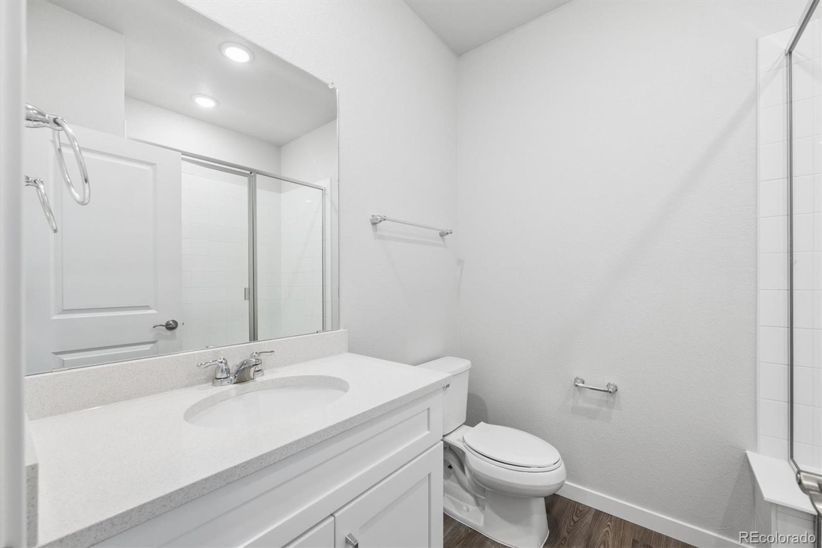 1414 Farmstead Street Brighton, CO 80601 - Photo 4 of 26 a bathroom with a sink toilet and a mirror