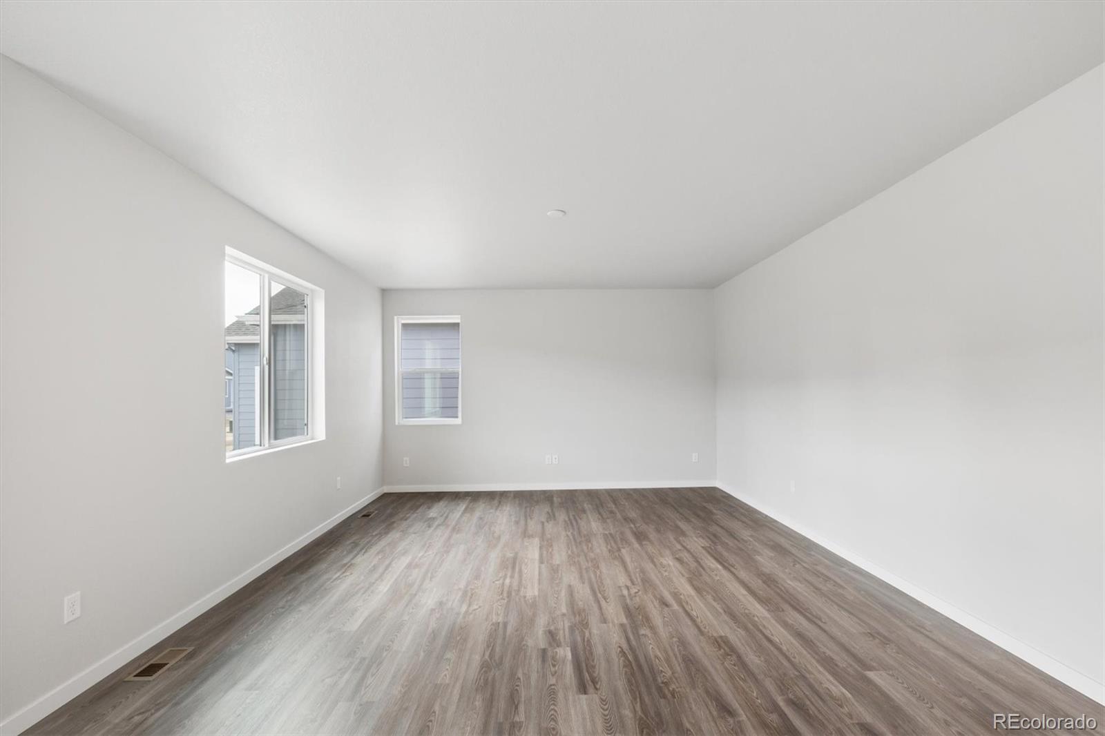 1414 Farmstead Street Brighton, CO 80601 - Photo 10 of 26 a view of an empty room with wooden floor and a window