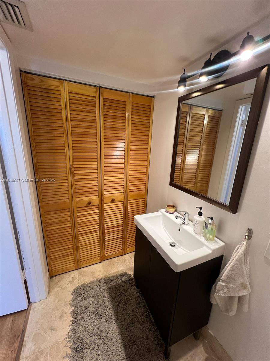 540 Brickell Key Drive, Unit 1524 Miami, FL 33131 - Photo 15 of 44 a bathroom with a sink vanity and a mirror