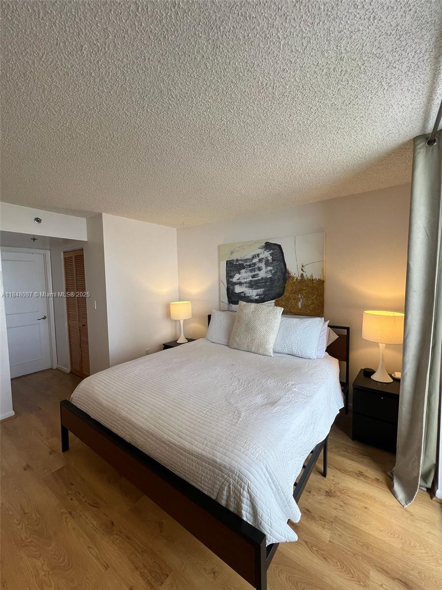 540 Brickell Key Drive, Unit 1524 Miami, FL 33131 - Photo 16 of 44 a bedroom with a bed and a lamp