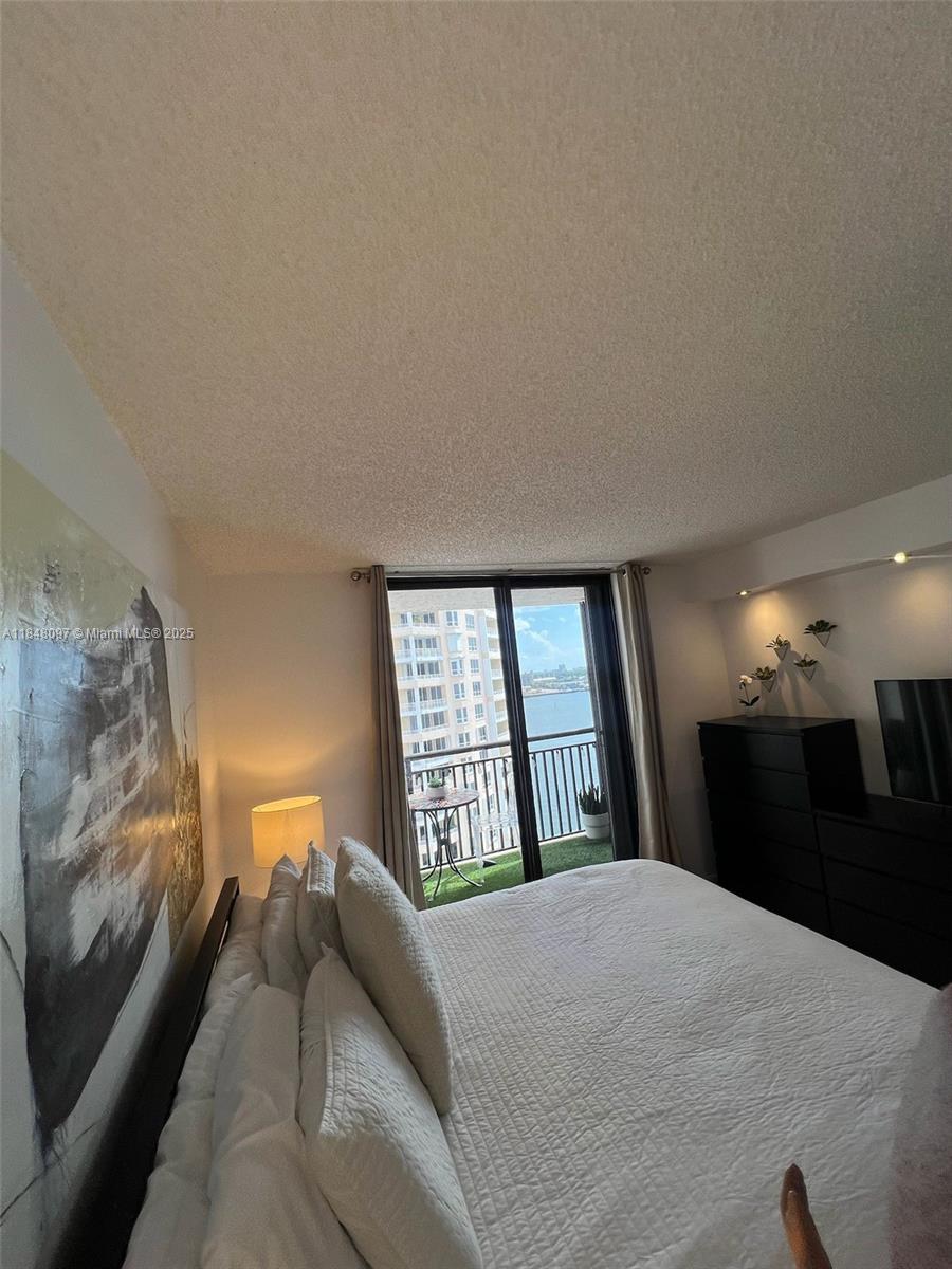 540 Brickell Key Drive, Unit 1524 Miami, FL 33131 - Photo 17 of 44 a bedroom with a bed dresser and mirror