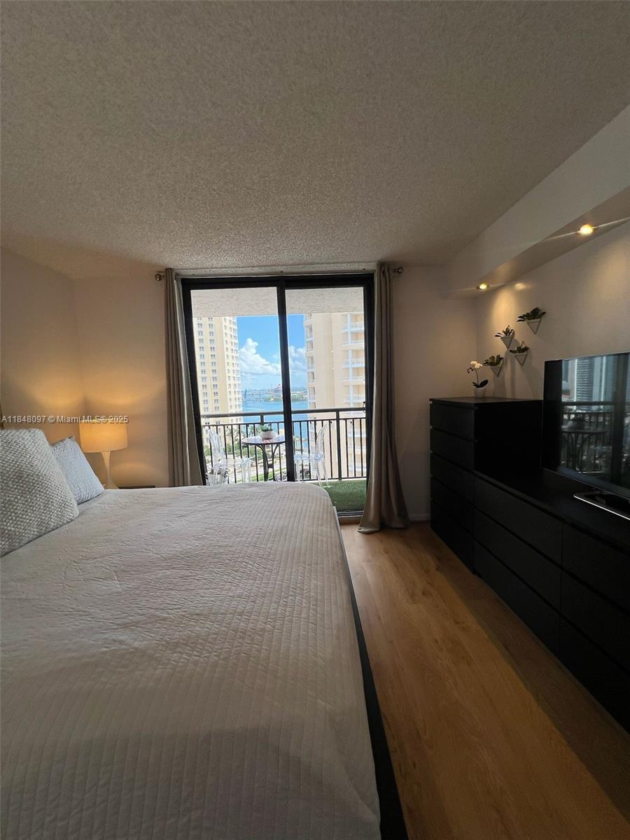 540 Brickell Key Drive, Unit 1524 Miami, FL 33131 - Photo 18 of 44 a bedroom with a balcony a bed and a large window