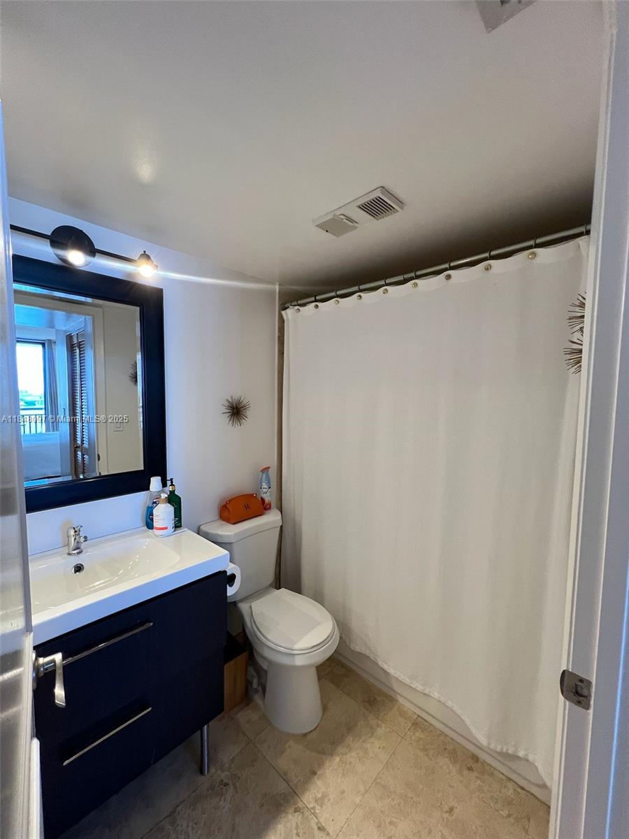 540 Brickell Key Drive, Unit 1524 Miami, FL 33131 - Photo 24 of 44 a spacious bathroom with a toilet sink and mirror