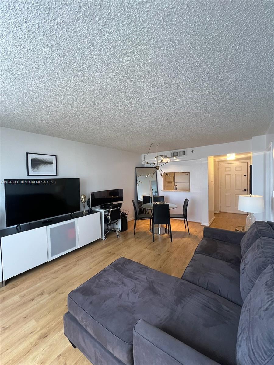 540 Brickell Key Drive, Unit 1524 Miami, FL 33131 - Photo 10 of 44 a living room with furniture and a flat screen tv