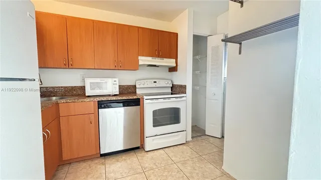 a kitchen with white cabinets and white appliances