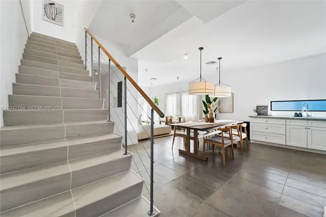 a view of a dining room and livingroom with furniture stairs and a chandelier