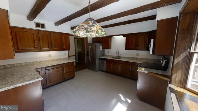 a kitchen with granite countertop stainless steel appliances and wooden cabinets