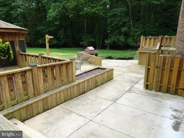 a view of a patio with table and chairs potted plants with wooden floor and fence