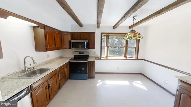 a kitchen with granite countertop a stove a sink and a microwave