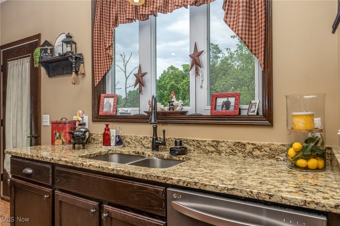 2851 Barnett Ridge Road Fleming, OH 45729 - Photo 18 of 40 Kitchen featuring dishwasher, a sink, dark brown cabinets, and granite countertops