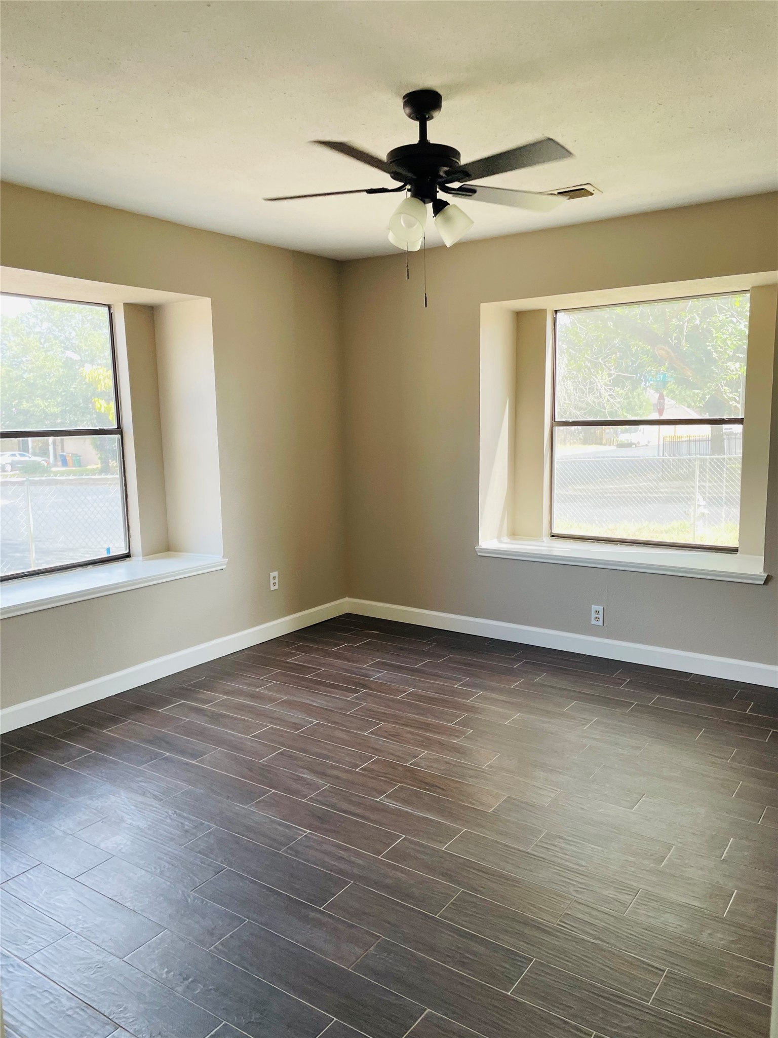 2406 Patsy Parkway Austin, TX 78744 - Photo 3 of 9 Empty room with dark wood-style flooring, ceiling fan, and plenty of natural light